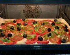 Step <p>Una vez extendida colocamos la verdura y la mezcla reservada. Adornamos con las aceitunas y horneamos a 230° unos 20-25 minutos (depende del horno). Dejamos templar </p><p>Y adórnanos con las hojas de albahaca</p> illustration