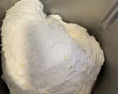 Step <p>Agregamos el agua restante, 20 g de aceite, las harinas y la sal. Amasamos durante 6 min.</p> illustration